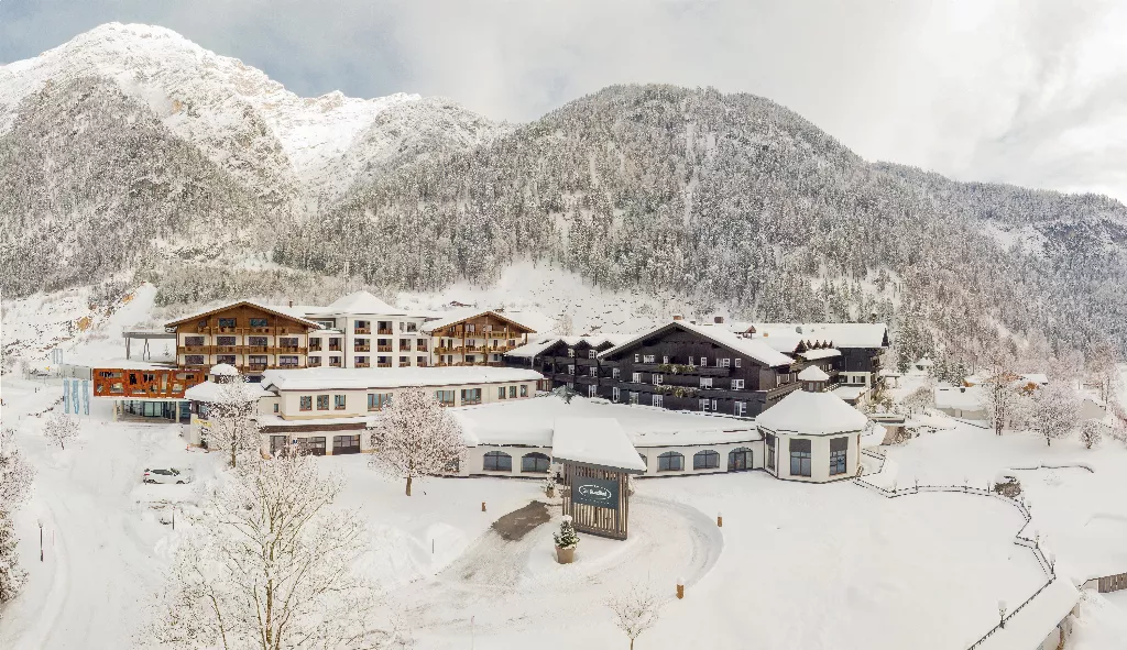 Blick auf das verschneite Hotel Gut Brandlhof in den österreichischen Alpen