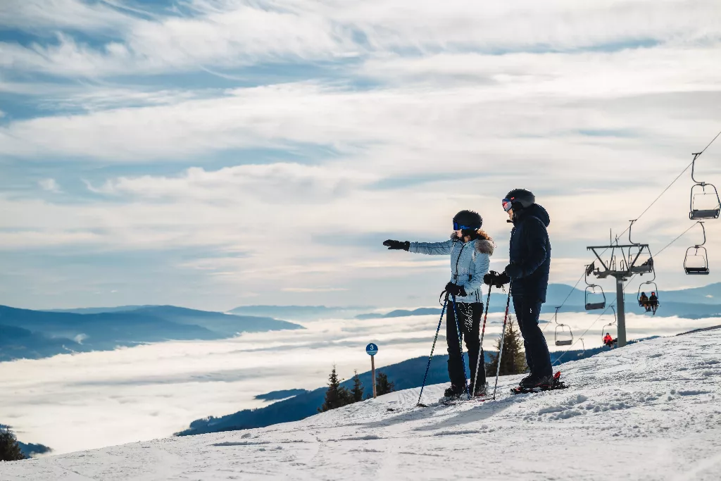 ein Mann und eine Frau stehen auf einer Skipiste